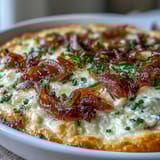 A warm, bubbly Smoked Gouda & Onion Dip topped with fresh chives is ready to scoop with crunchy tortilla chips.