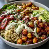 Colorful Buddha Bowl with Quinoa, Roasted Sweet Potatoes, Crispy Chickpeas, fresh veggies, and avocado slices, ready to serve.