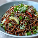 Chilled soba noodles, colorful vegetables, and sesame ginger dressing in a refreshing summer salad.