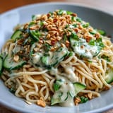Flavorful Asian-inspired noodle bowl topped with crunchy peanuts and fresh scallions.