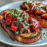 Crisp sourdough topped with jewel-toned strawberries and a tangy balsamic glaze for delicious bites.