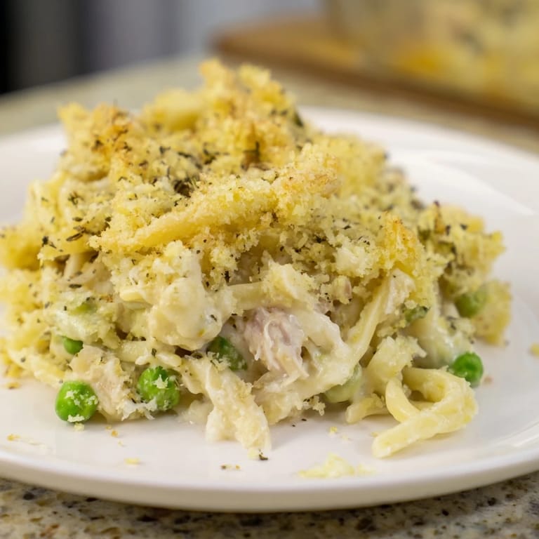 A close-up shot of creamy tuna casserole, filled with tender noodles and sweet peas, ready to serve. 