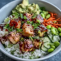 Flaky broiled salmon cubes and vibrant fresh vegetables sit atop fluffy steamed rice in this Baked Salmon Rice Bowl.  